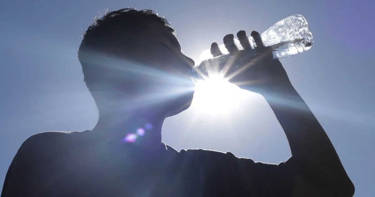 Hombre tomando agua por altas temperaturas/ EsImagen