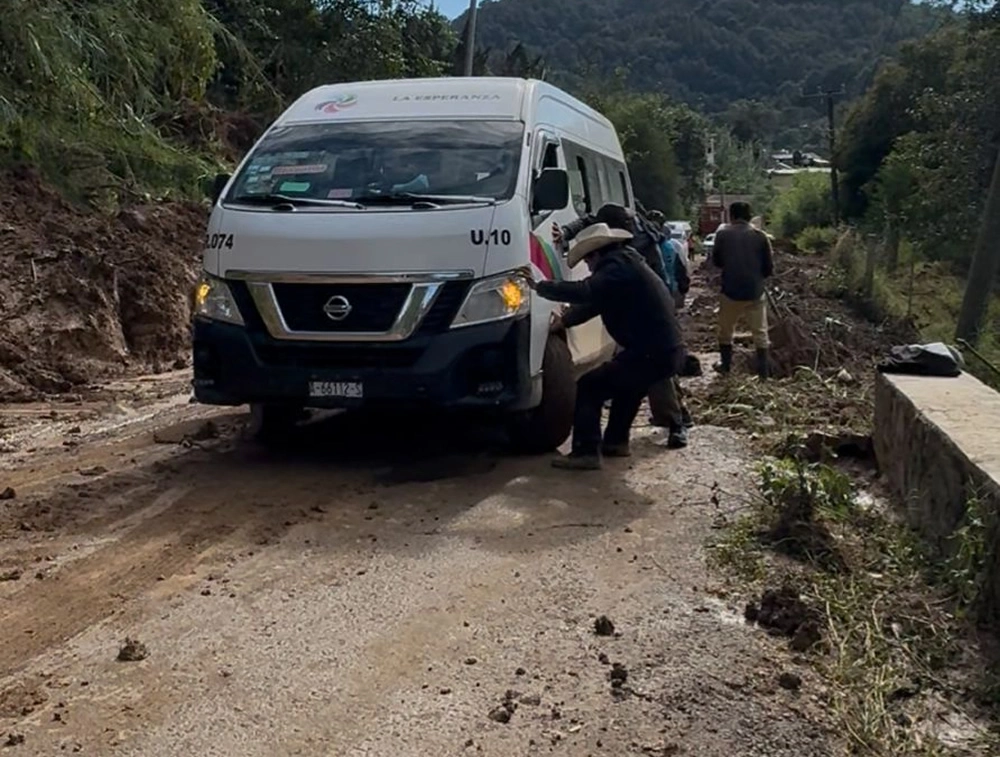 Omar Cuevas / Habitantes de Nopala ayudan a empujar transporte público atorado en las afectaciones carreteras