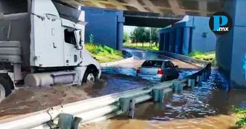 El agua alcanzó un nivel aproximado de 30 centímetros, lo que dejó al vehículo inmovilizado en el carril bajo el puente