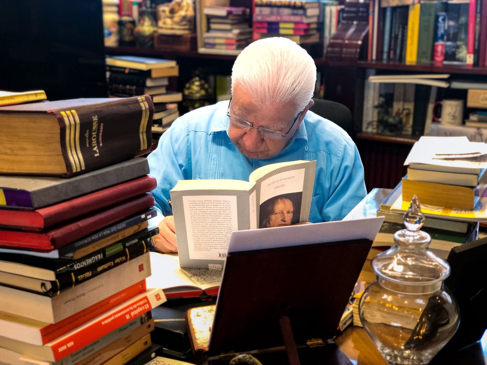 Maestro Aquiles en su escritorio junto a libros como “El Capital” de Marx, Tomo II, o los “Fragmentos”, del primer filósofo dialéctico Heráclito