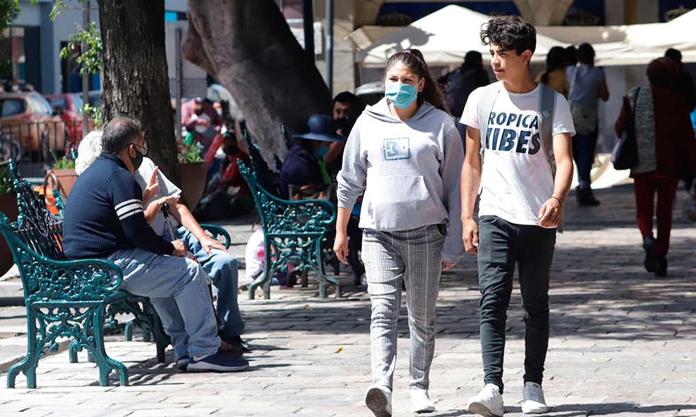 Jóvenes pasean en el zócalo de la ciudad de Puebla. 